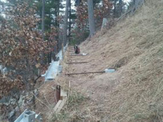 Retaining wall tiebacks drilled into a hill in Ada Michigan.