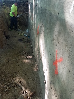 A Kent Foundation Repair employee marks areas on a bowed basement wall in Bryon Center, Michigan.